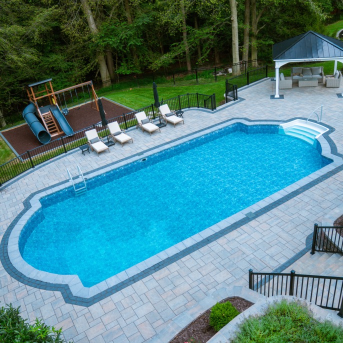 Concrete pool with pavilion and fenced yard